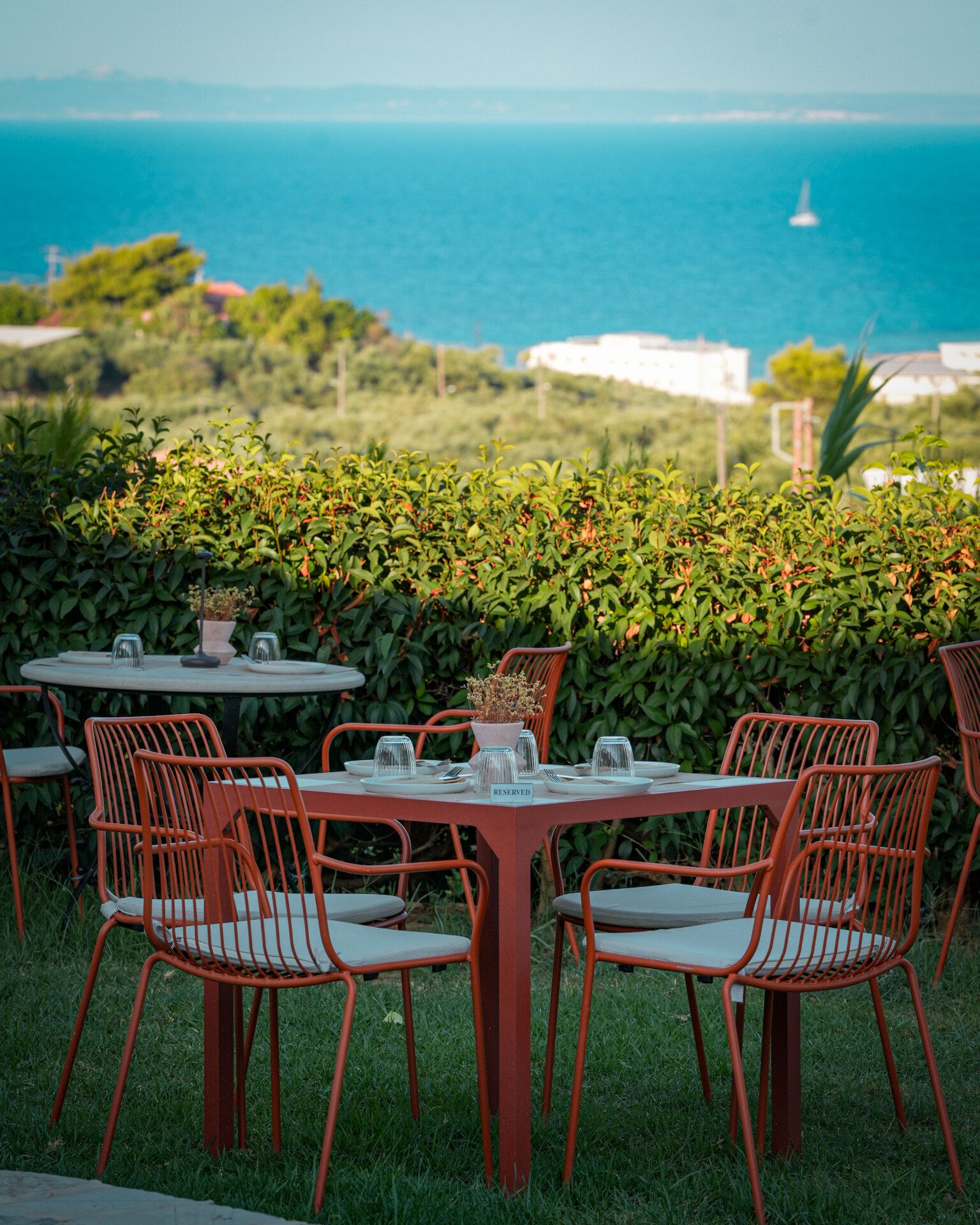 Tables in the Meraki garden with a view of the sea