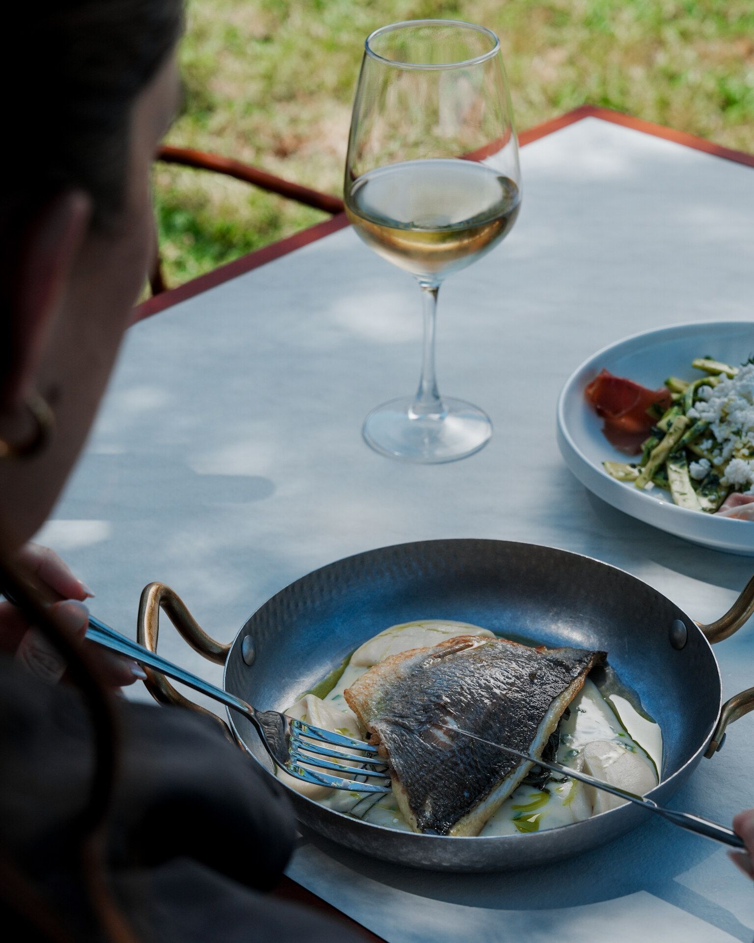Grilled fish served with a glass of white wine