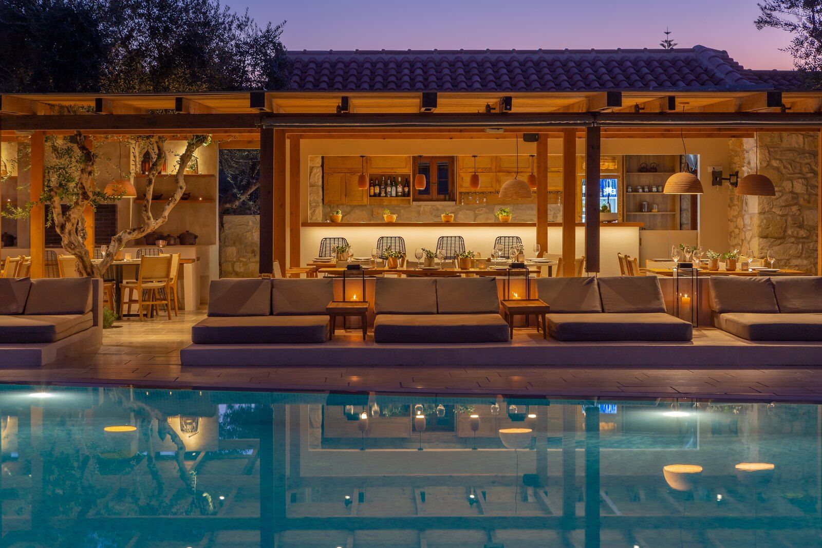 The bar lit up in the evening, across the pool