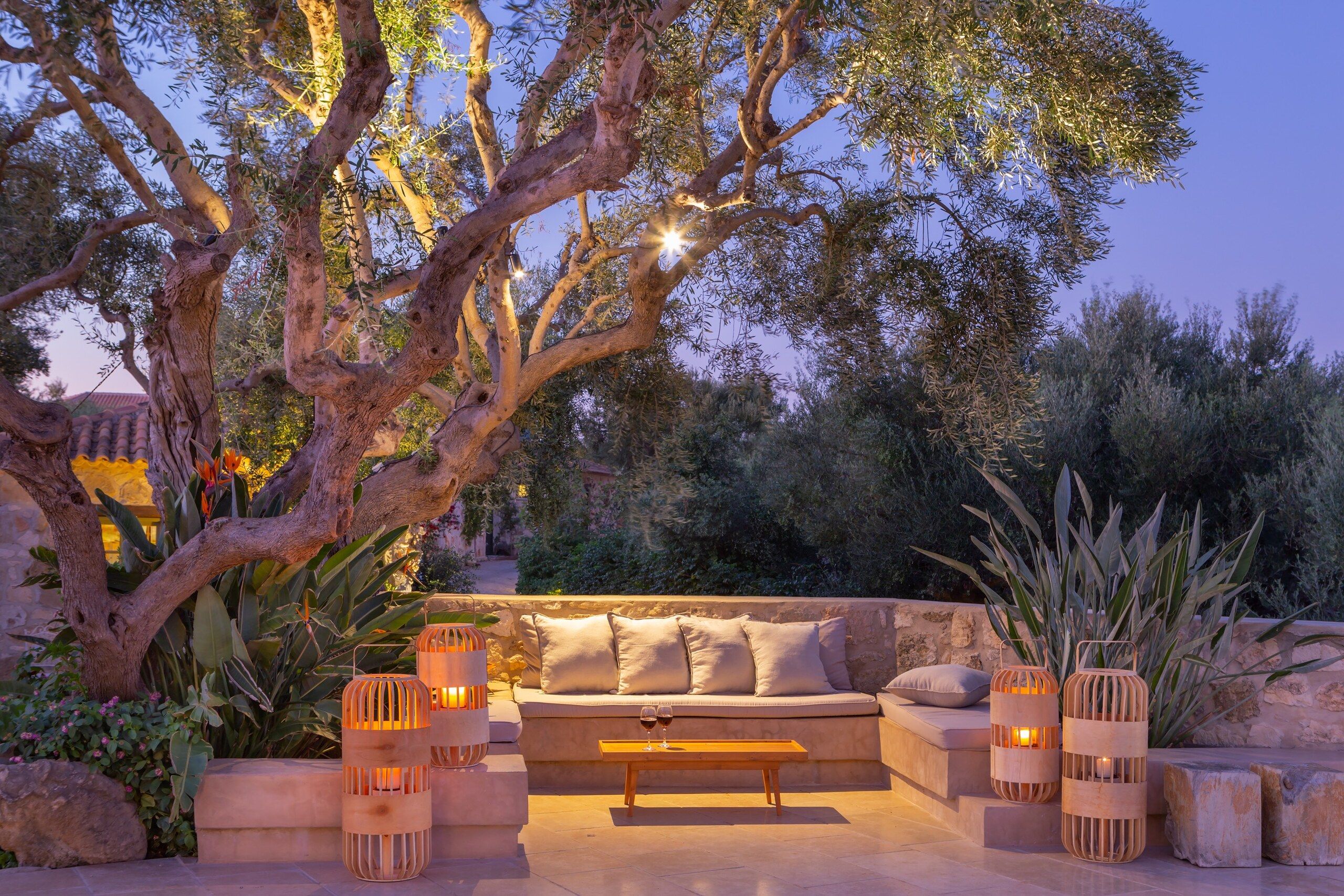 A candle-lit sitting corner under an old olive tree in the evening