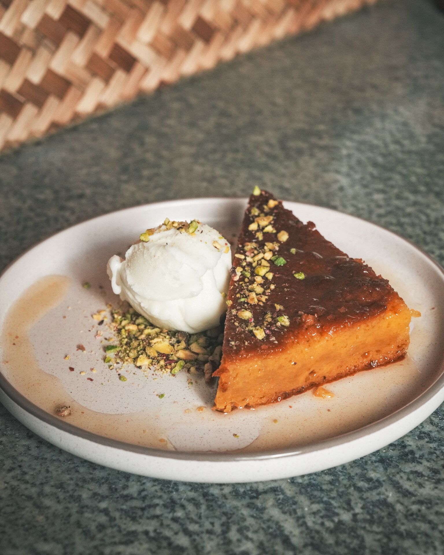 A slice of cake with ice cream and pistachio
