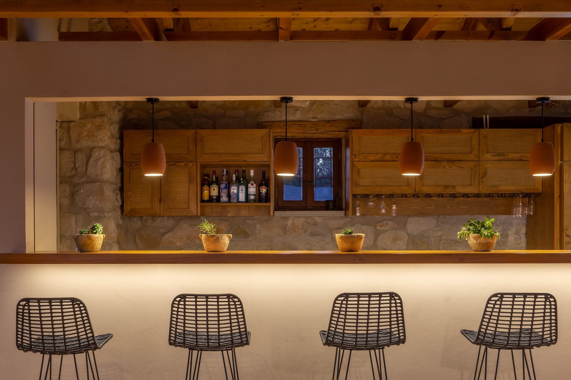 Bar stools at the stone bar, lit in the evening
