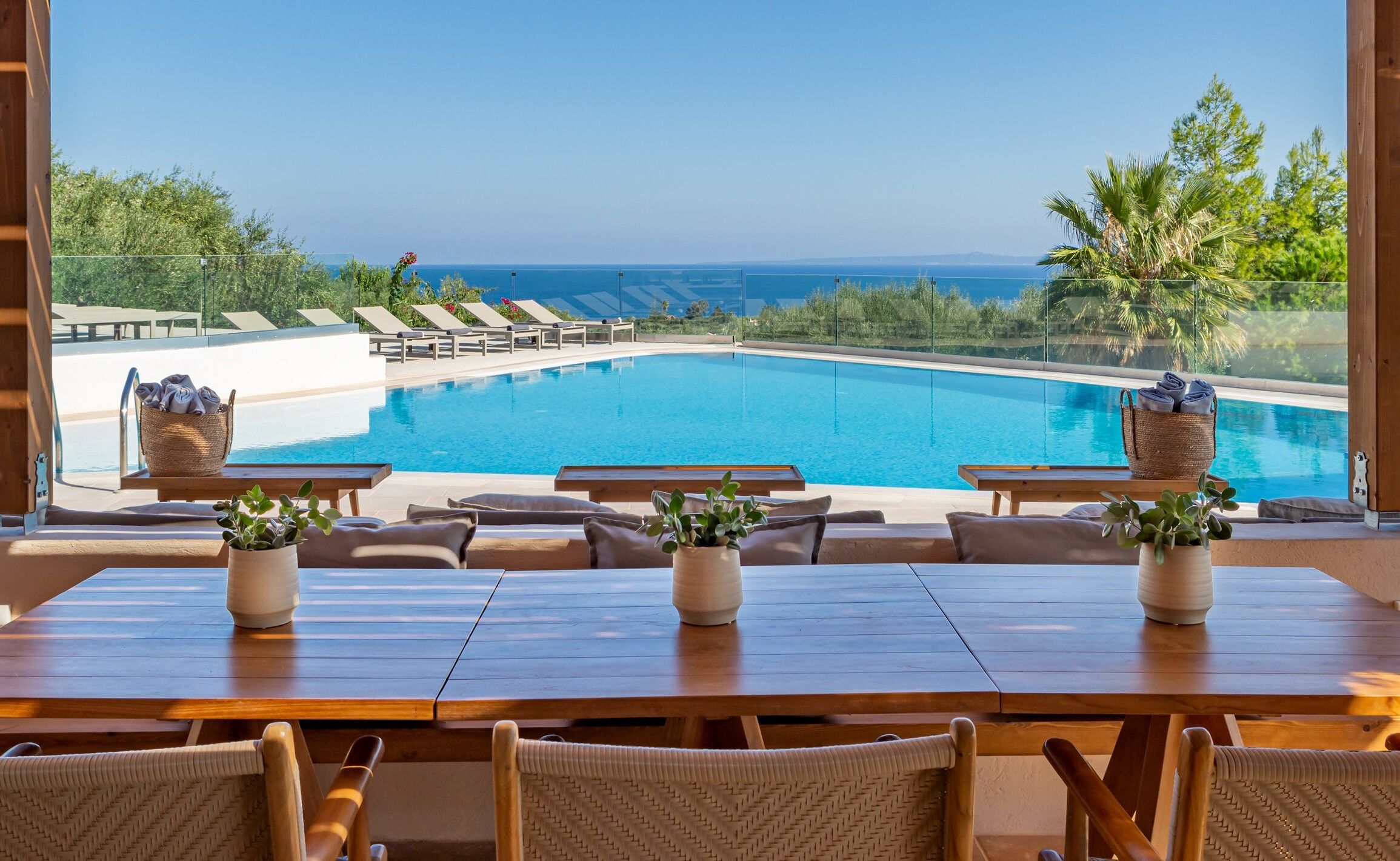The pool of Paliokaliva Village seen from the bar terrace, with the Ionian Sea behind
