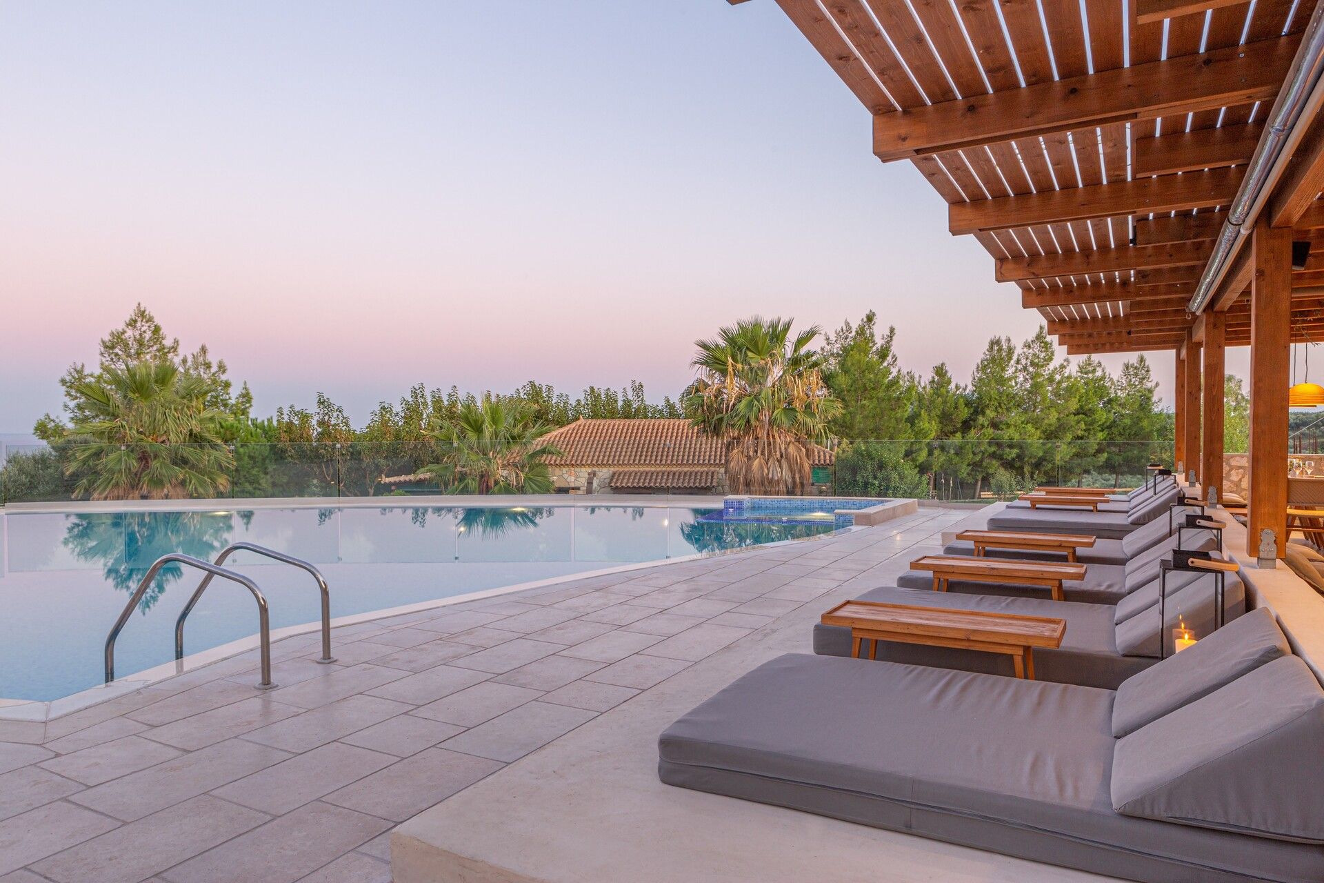 Sun loungers by the pool at sunset