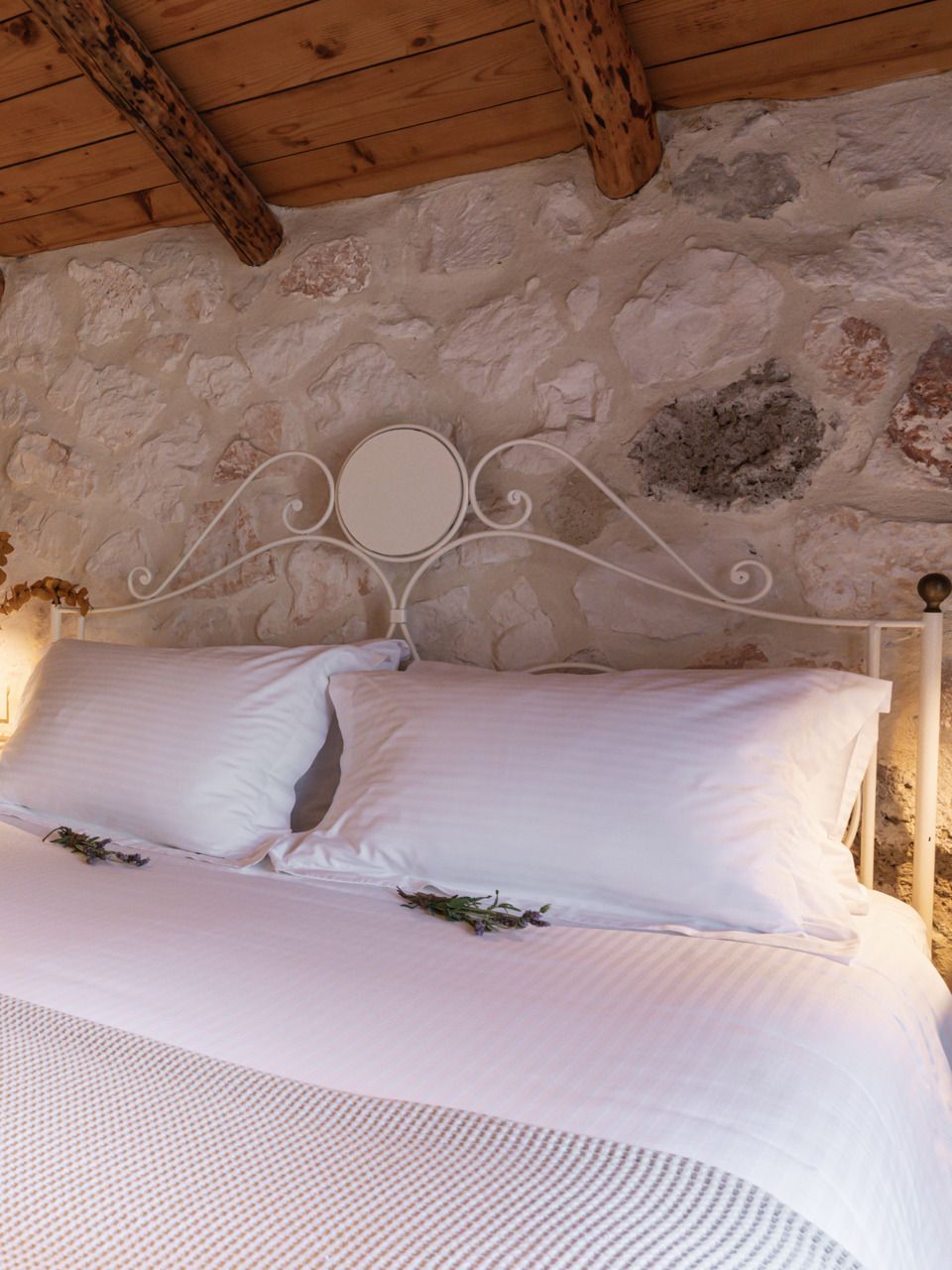 Apartment bedroom with an iron bed under wooden beams